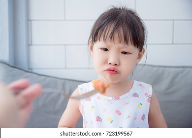 Little Asian Girl With Unhappy Face Between Mother Want Her To Having Food For Lunch,picky Eater Child Concept.