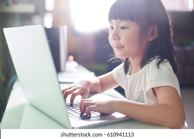 Little asian girl  using laptop to studying . selected focus on eye with blurred background .