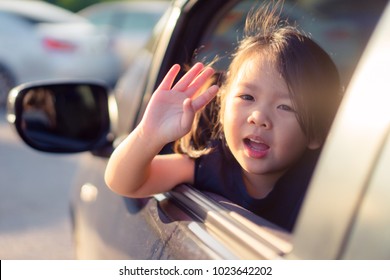 Little Asian Girl Waving Hand For Good Bye In The Are.Concept: Bye, Summer! Outdoor Portrait: Beautiful Kid Smiling And Waving Say Good Bye.