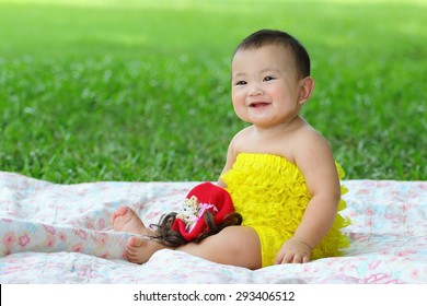 Little Asian Girl Wearing A Yellow Dress Was Playing Happily And Smiling In The Park, Close Up