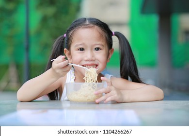 Little Asian Kid Girl Eating Instant Noodles In The Morning