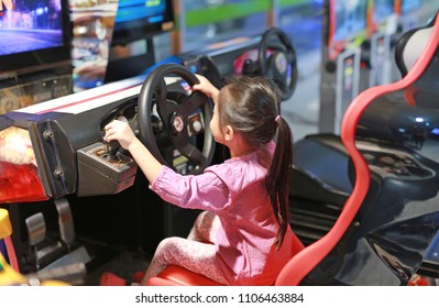 Little Asian Kid Girl Playing Game Arcade Racing Car.