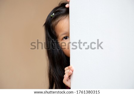 Little Asian kid peeking at the corner