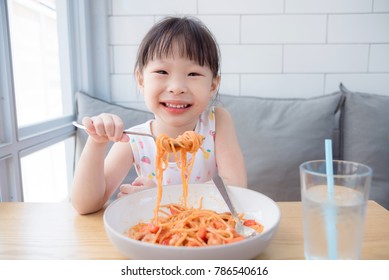 Little Asian Pretty Girl Using Fork Eating Spaghetti By Herself