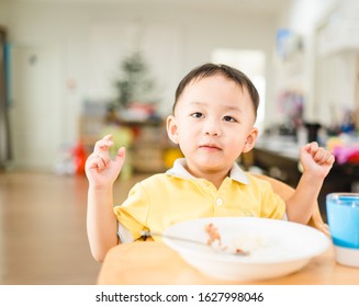 Little Asian Toddler Boy Make Boring Face When He Eat Vegetable In Breakfast.Unhappy, Disgusted, Unlike Food In The Morning Concept.Little Asian Boy Child With No Appetite In Front Of The Meal.