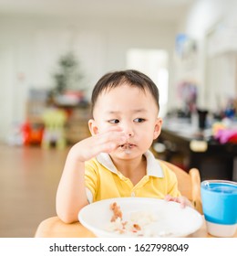 Little Asian Toddler Boy Make Boring Face When He Eat Vegetable In Breakfast.Unhappy, Disgusted, Unlike Food In The Morning Concept.Little Asian Boy Child With No Appetite In Front Of The Meal.