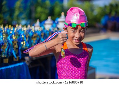 Little athlete swimming girl celebrate with golden medal from competition - Powered by Shutterstock