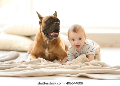 Little Baby Boy With Boxer Dog Lying On The Floor At Home