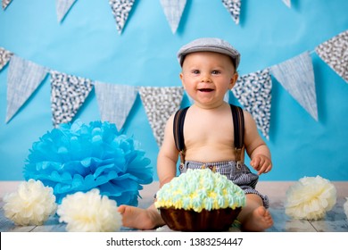 Little Baby Boy, Celebrating His First Birthday With Smash Cake Party, Studio Isolated Shot On Blue Background