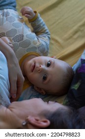 Little Baby Boy Curious Face Laying In Bed With Mother