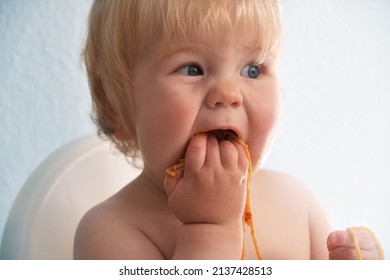 Little Baby Boy Eating Spaghetti Bolognese. Cute Kid Making A Mess. Close Up Portrait