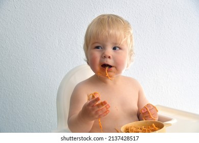 Little Baby Boy Eating Spaghetti Bolognese. Cute Kid Making A Mess. Close Up Portrait