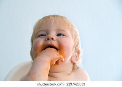 Little Baby Boy Eating Spaghetti Bolognese. Cute Kid Making A Mess. Close Up Portrait