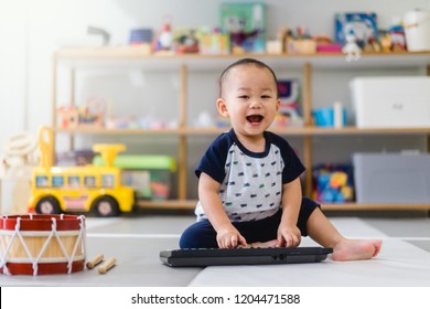 Little baby boy play keyboard and drum at home.Asian boy playing and singing happy moment in music time.