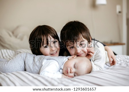 Similar – Image, Stock Photo Happy little girl holding doll and cookie while woman playing with a boy over the bed. Weekend family leisure time concept.