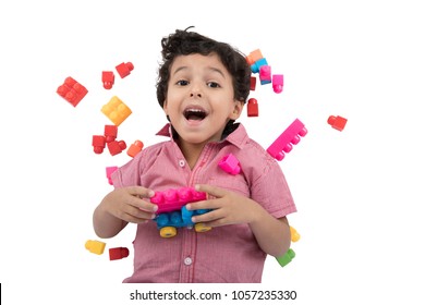 A little baby boy sleeping on the floor, the cubes around him, smiling with an open mouth, isolated on a white background.