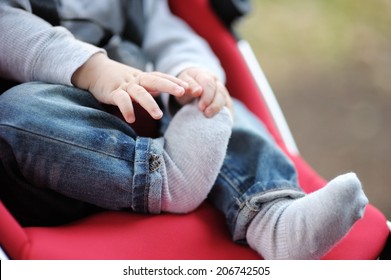 Little Baby Boy In Stroller Playing With His Sock 