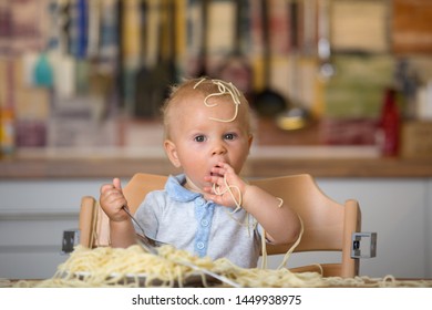 Little Baby Boy, Toddler Child, Eating Spaghetti For Lunch And Making A Mess At Home In Kitchen