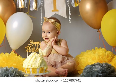 Little baby celebrating its first birthday, in front of him cake with candle in the form of 1