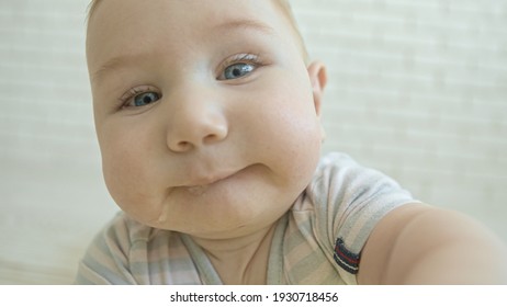 A Little Baby Curious Caucasian Baby Reaching For The Camera