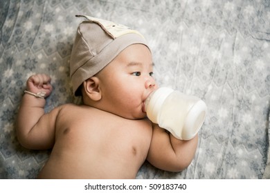 Little baby drinking milk from bottle.