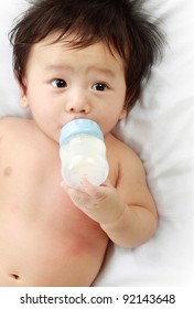 Little baby drinking milk from bottle.