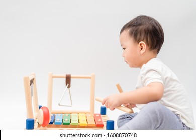 Little baby drummer boy playing percussion and hitting the drum set at home.Asian boy playing and singing happy moment in music lesson time.Child development and Executive function in child concept.