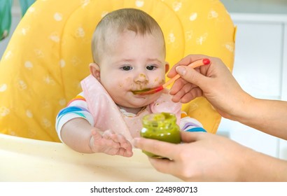 Little baby is eating broccoli vegetable puree. Selective focus. People. - Shutterstock ID 2248980713