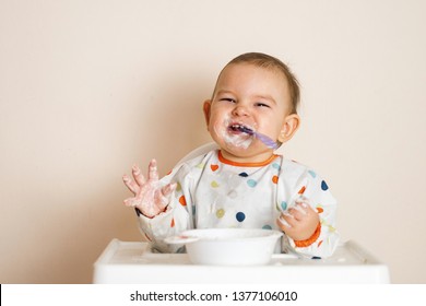 A Little Baby Eating Her Dinner And Making A Mess