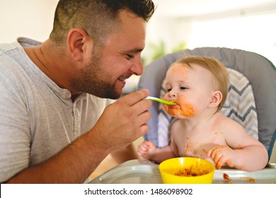 A Little Baby Eating Her Dinner And Making A Mess With Dad On The Side