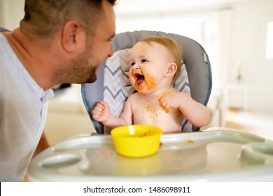 A Little Baby Eating Her Dinner And Making A Mess With Dad On The Side