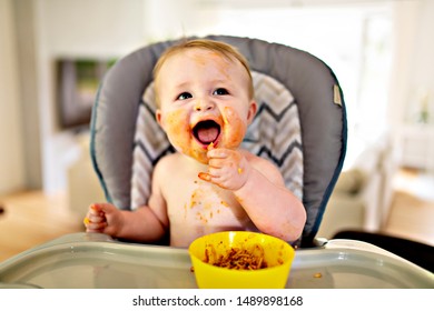 A Little Baby Eating Her Dinner And Making A Mess