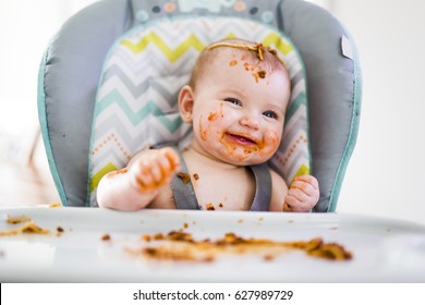 A Little Baby Eating Her Dinner And Making A Mess