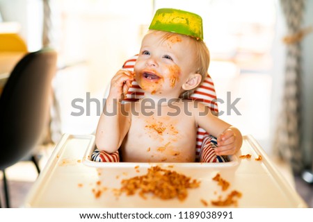 Little baby eating spaghetti dinner and making a mess