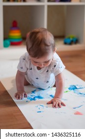 Little Baby Is Engaged In Finger Painting. Early Development. Todler Playing With Paints On Drawing Paper. Small Child's Hands Painted In Colorful Paints. Playing. Education, Creativity.