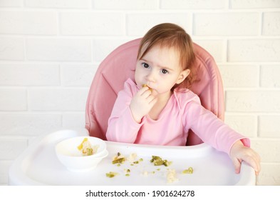 Little Baby Girl Eating Her Dinner And Making A Mess. Top View