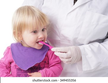 Little Baby Girl Gets Help By The Dentist To Brush Her Teeth, Isolated On White