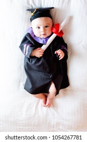 Little baby girl in graduation cap and gown