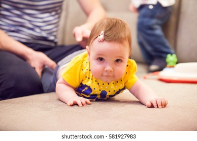 Little baby girl learning to crawl on the couch