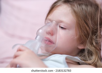 Little Baby Girl With Oxygen Mask Lying On Hospital Bed Or At Home