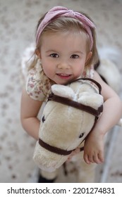 Little Baby Girl Sitting On Rocking Horse