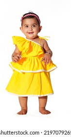 Little Baby Girl Standing Pose Wearing Yellow Frilled Frock, Isolated On White Background