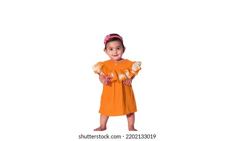 Little Baby Girl Standing Pose Wearing Light Orange Frock, Isolated On White Background