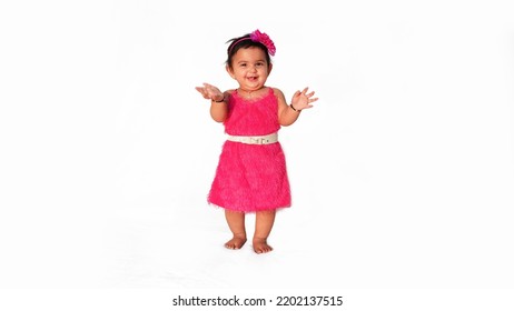 Little Baby Girl Standing Pose, Looks Beautiful In Pink Fur Frock, Isolated On White Background