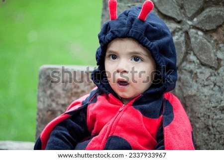 Little baby girl wearing a ladybug costume. Halloween concept.