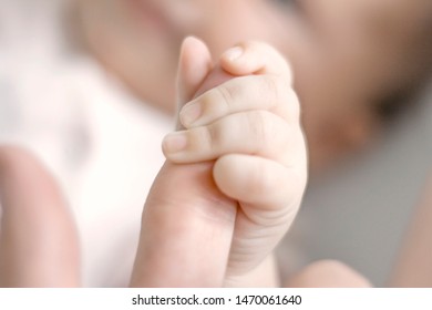 Little Baby Holding Mom's Finger