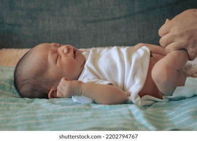 A Little Baby Lying Down Getting Cleaned Up And Diaper Changed. Newborn Care. Mother And Baby.