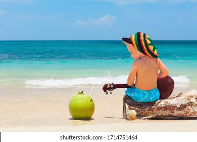 Little Baby In Rasta Hat Play Reggae Music On Hawaiian Ukulele, Enjoy Relaxing On Ocean Beach. Kids Healthy Lifestyle. Family Summer Holiday. Activity On Tropical Jamaica And Caribbean Island Travel.