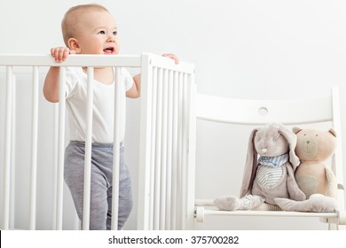 Little Baby Standing In His Crib.