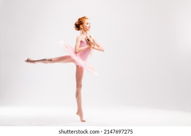 Little ballerina dancer in a pink tutu academy student posing on white background - Powered by Shutterstock